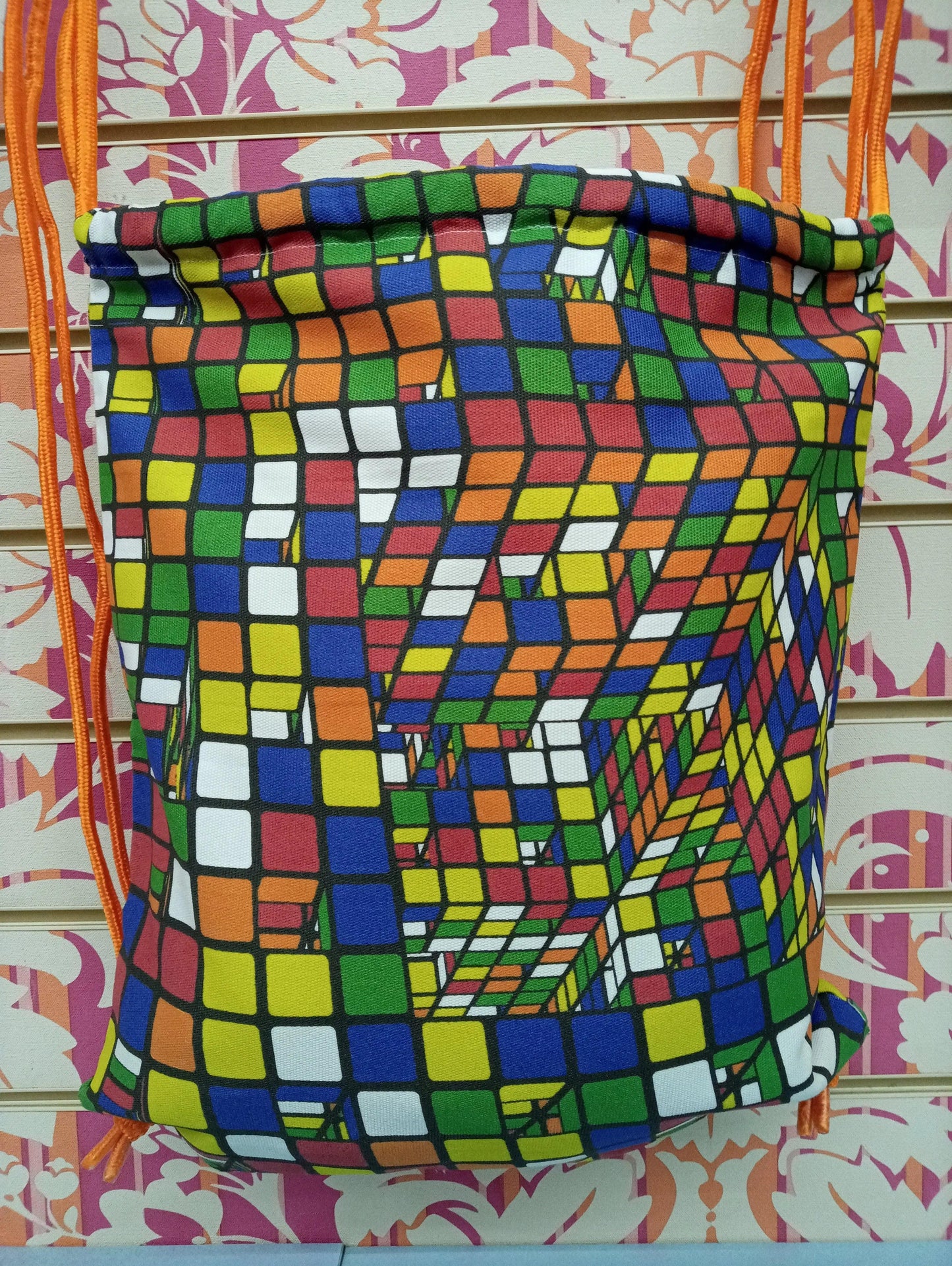 Zaino a sacca streetwear con motivo cubi colorati, stile urban, sfondo rosa decorativo