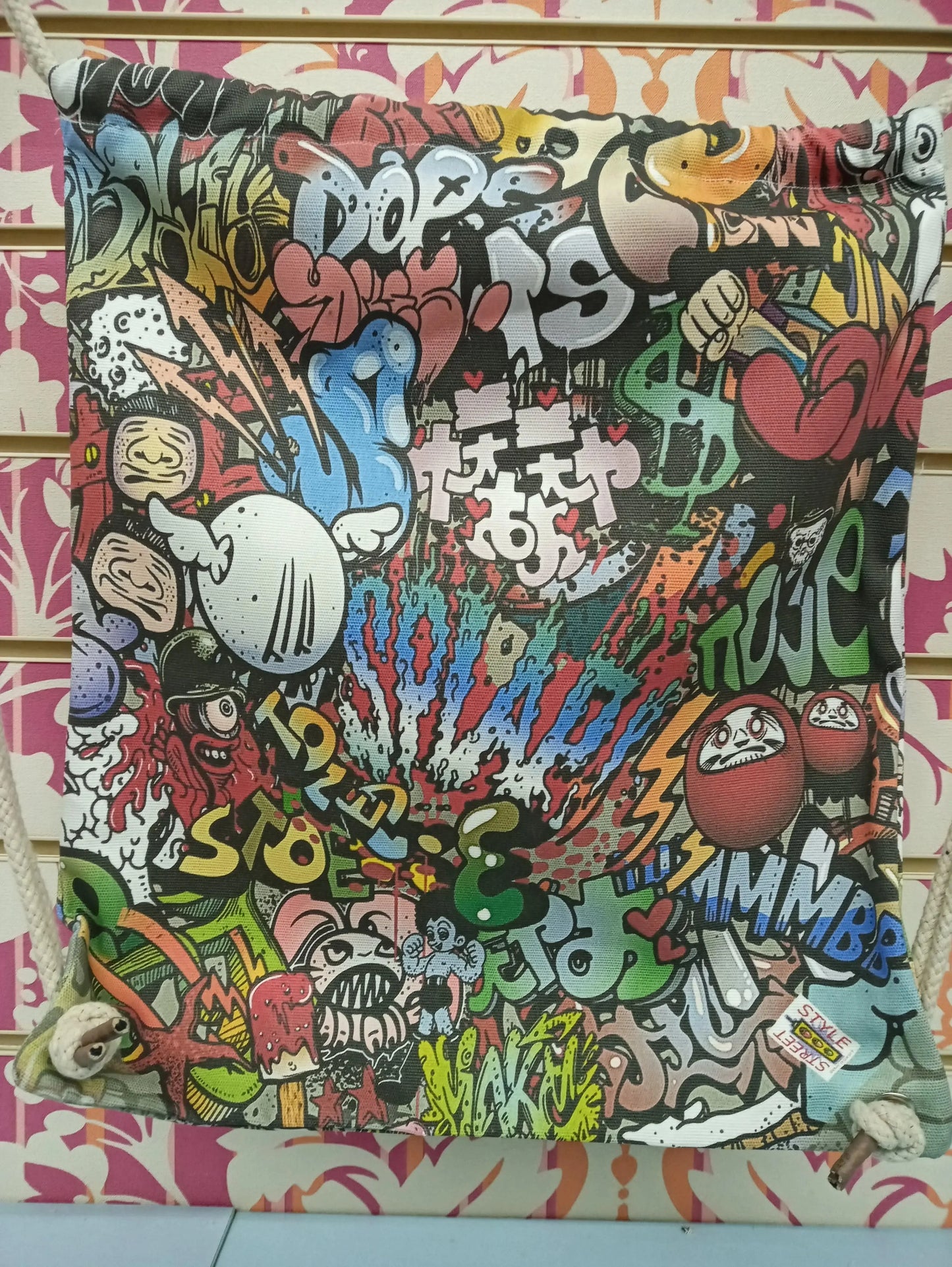 Zaino a sacca streetwear con graffiti colorati e motivi urban, stile street style Rimini