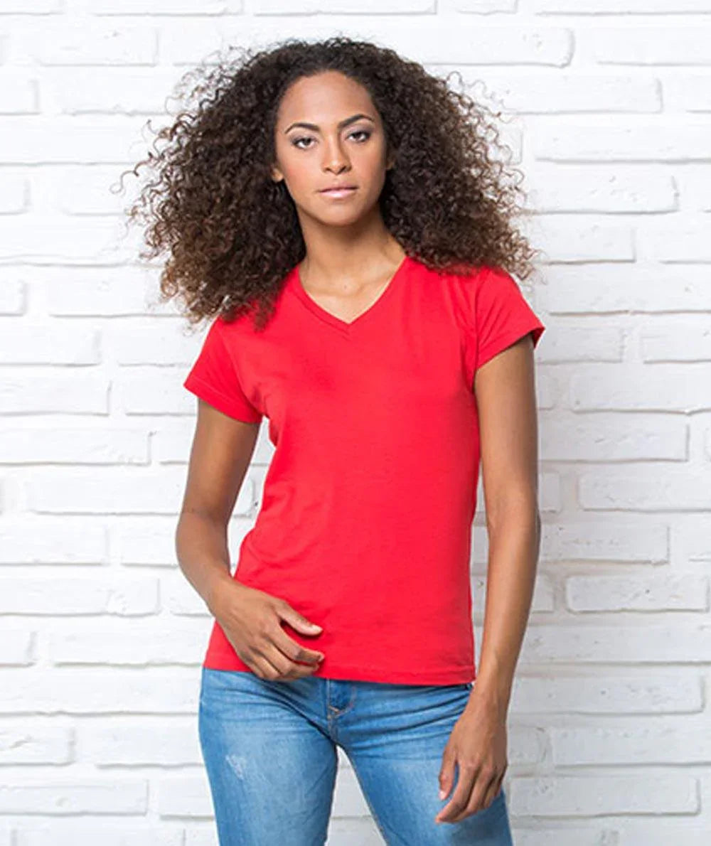 Donna con t-shirt rossa streetwear e jeans, stile urban casual, sfondo muro bianco