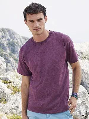 Modello uomo indossa t-shirt streetwear viola melange in cotone, look urban, sfondo roccioso.