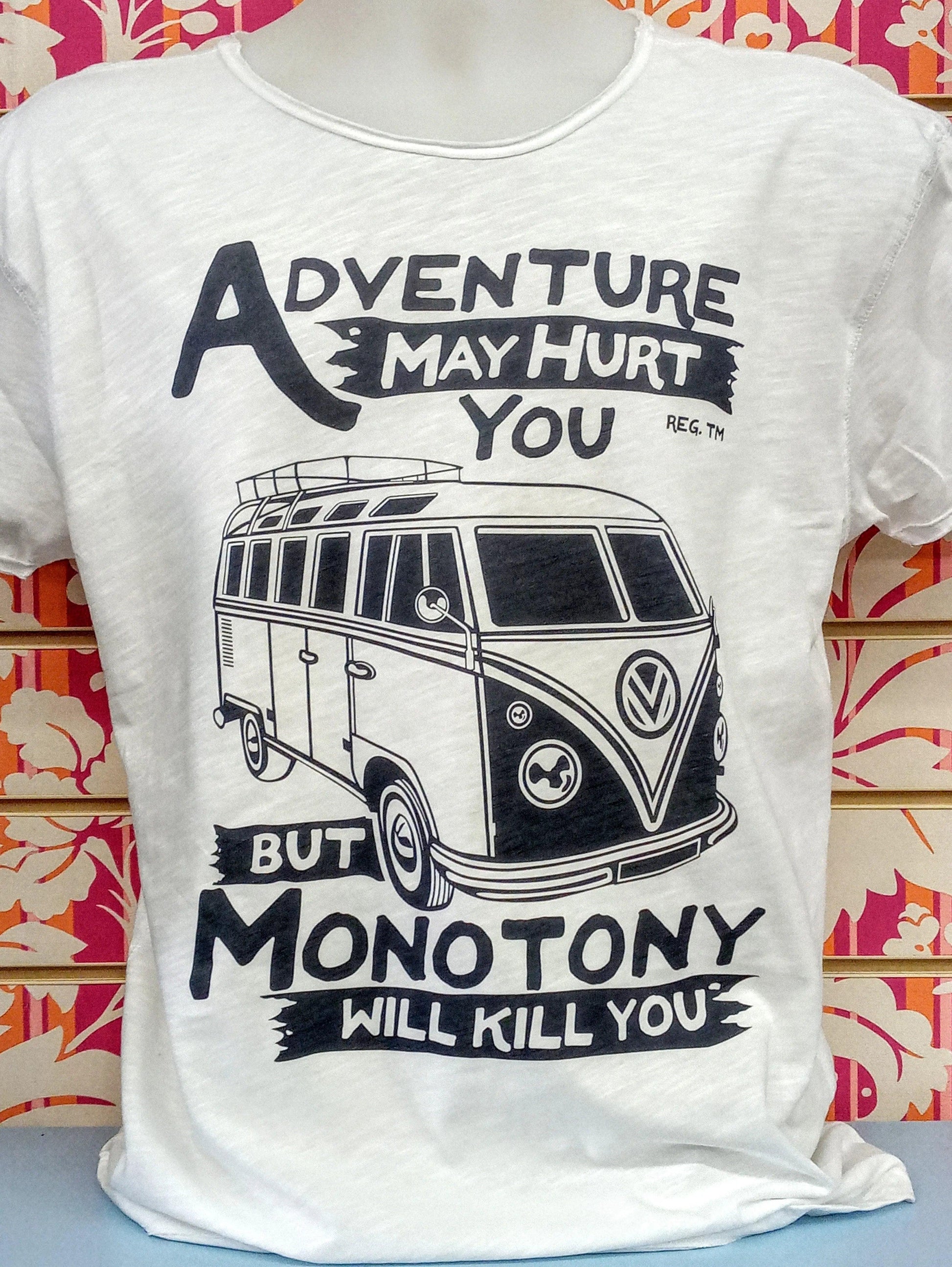 T-shirt streetwear bianca con grafica van e scritta 'Adventure may hurt you but monotony will kill you', stile urban.