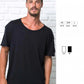 Modello streetwear uomo con t-shirt urban nera, fondo muro bianco, stile casual Street Style.