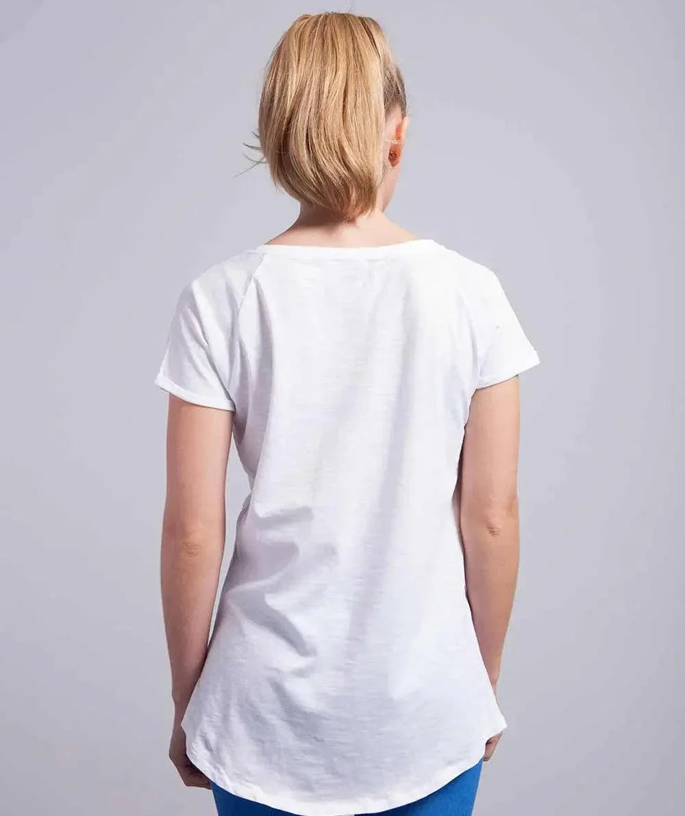 Donna di spalle con t-shirt bianca 100% cotone, streetwear essenziale stile urban.