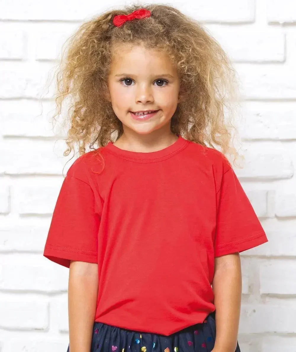Bambina streetwear con t-shirt rossa, fiocco rosso e sfondo muro bianco, stile urban