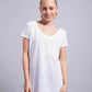 Donna con t-shirt bianca basic, street style minimal su sfondo neutro