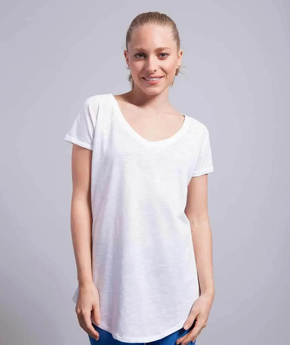 Donna con t-shirt bianca basic, street style minimal su sfondo neutro