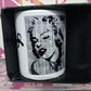 Tazza mug bianca con grafica street art di donna iconica, esposta in scatola nera, streetwear