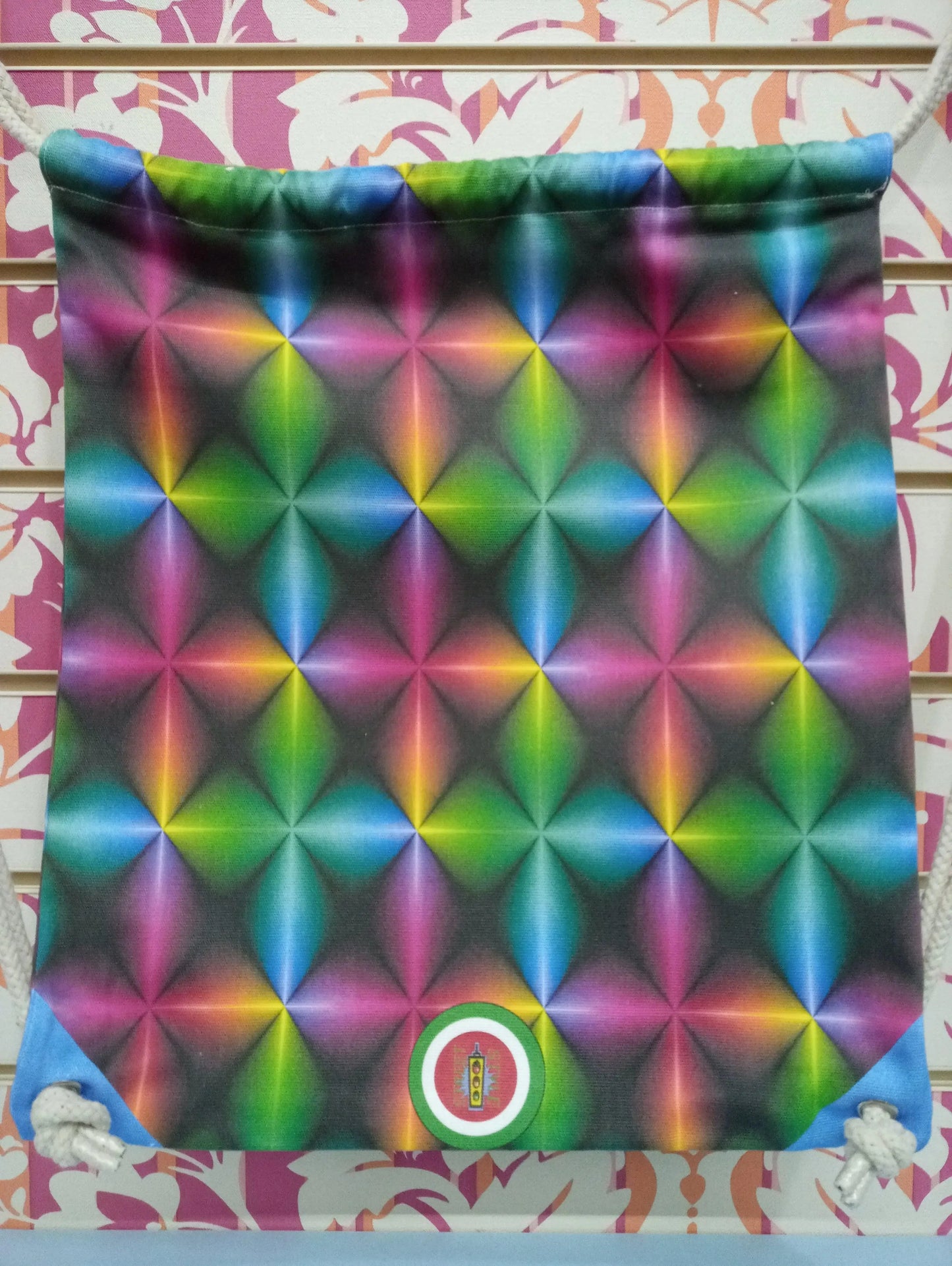 Zaino a sacca streetwear con stampa 3D colorata, stile urban, su sfondo decorativo.