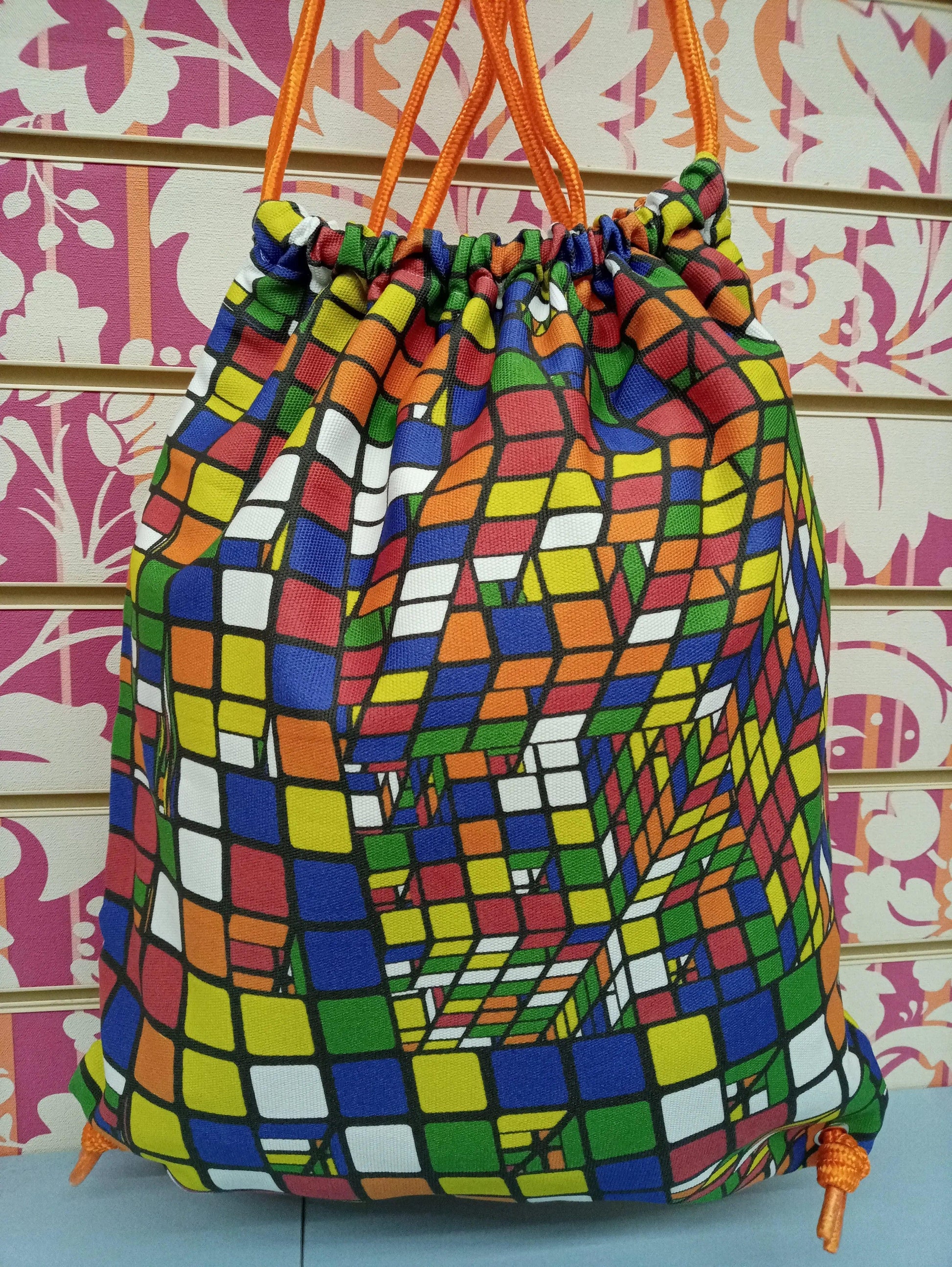 Zaino a sacca streetwear con stampa cubo colorato, stile urban, cordini arancioni