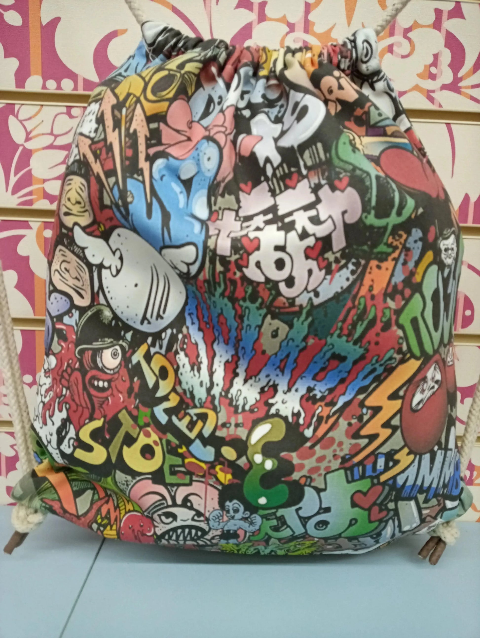 Zaino a sacca street style con grafica cartoon colorata, perfetto per look urban e streetwear.