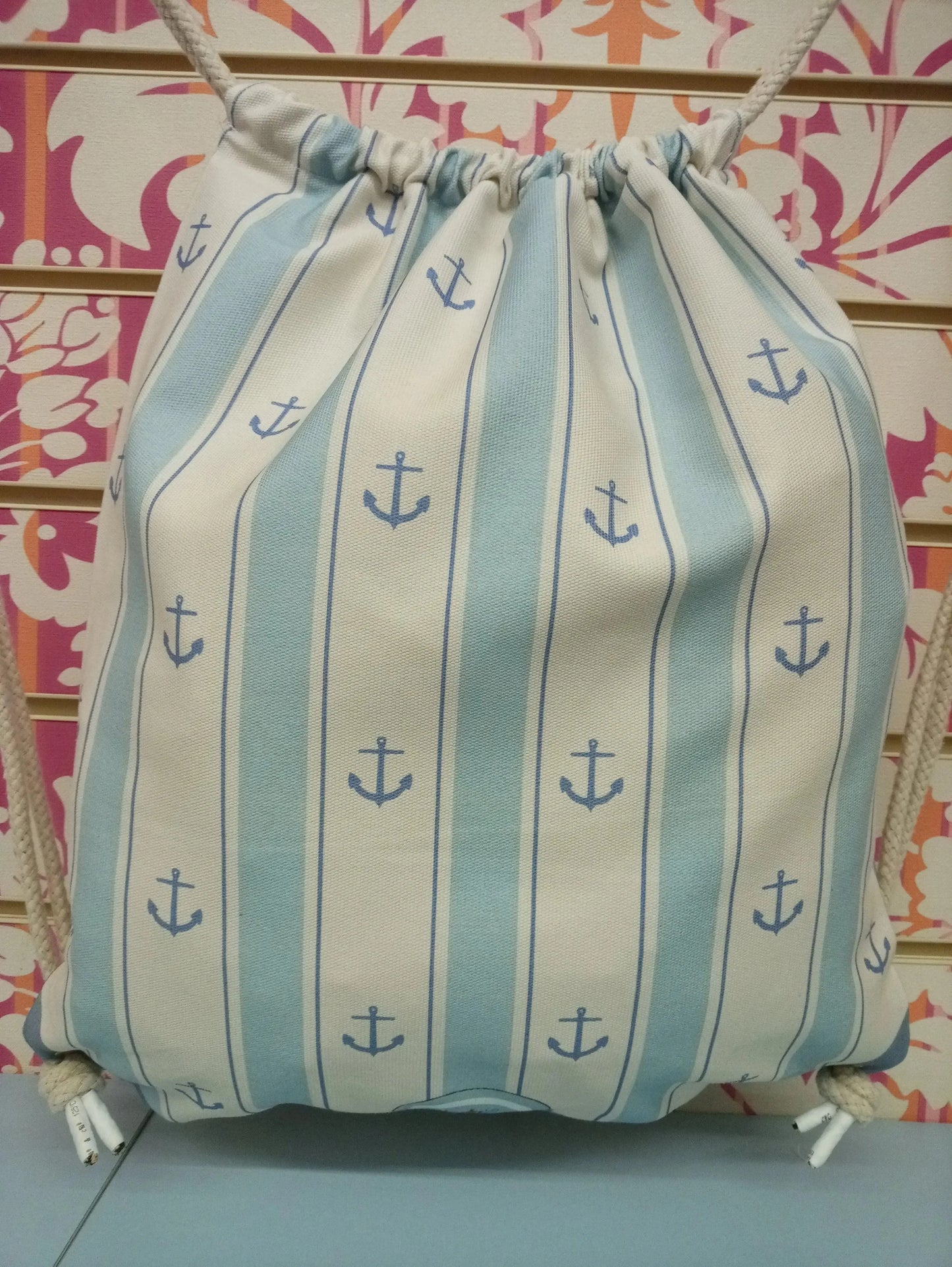 Zaino a sacca stile streetwear con righe azzurre e ancore blu, sfondo decorativo colorato