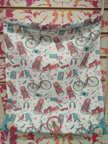 Zaino a sacca in tessuto bianco fantasia urban con scarpe, bici, cuffie e dettagli rosa blu