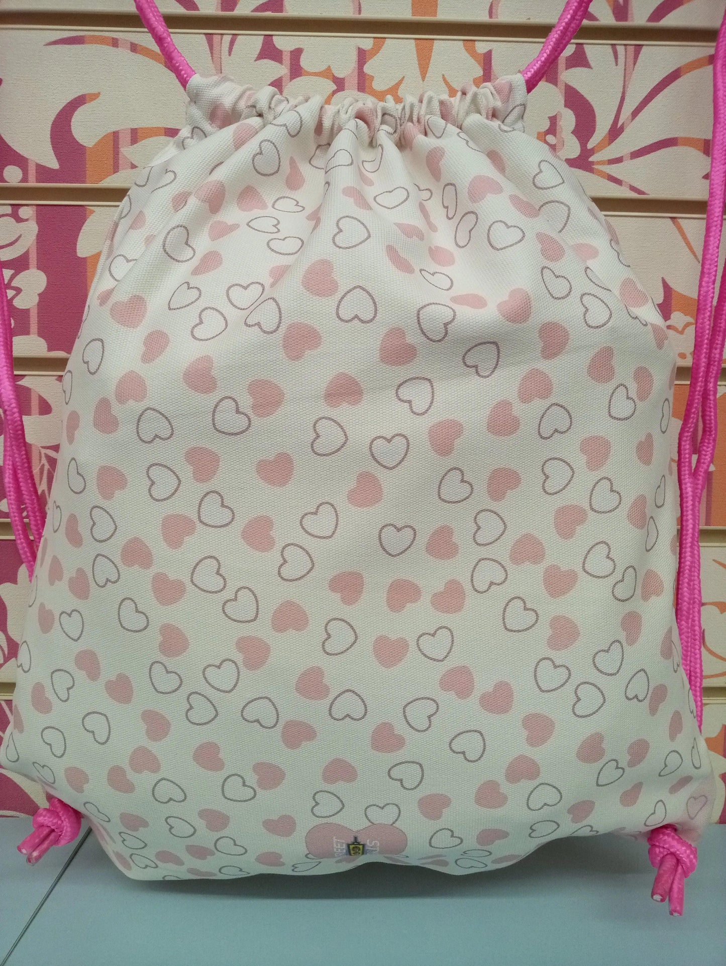 Zaino a sacca streetwear bianco con cuori rosa, cordini rosa, stile street style Rimini