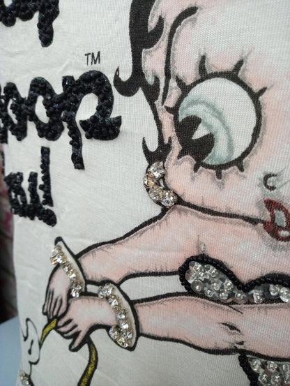 Dettaglio t-shirt streetwear bianca con stampa cartoon e applicazioni strass, stile urban