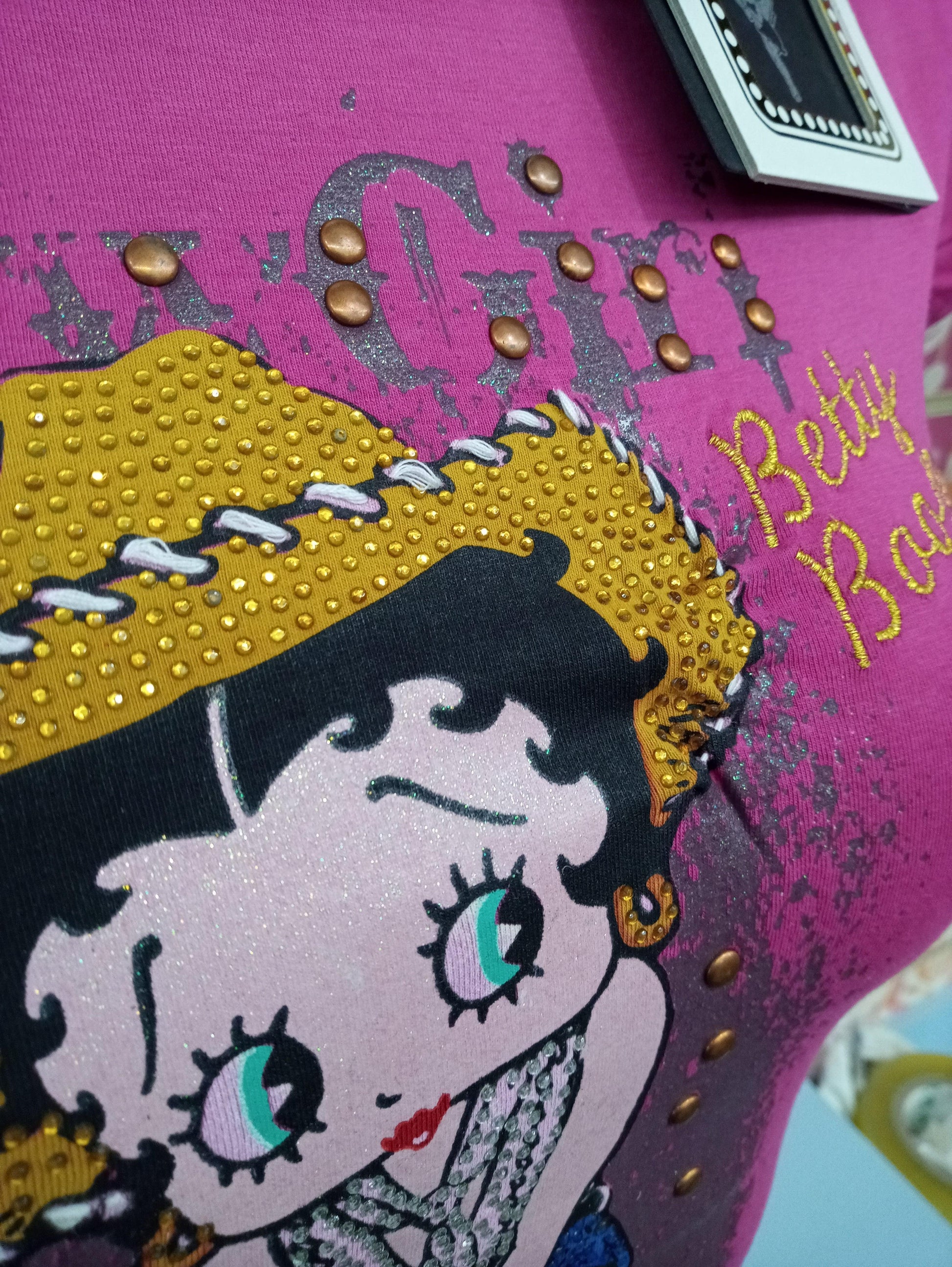 T-shirt streetwear rosa con stampa Betty Boop, dettagli glitterati e borchie, stile urban donna.